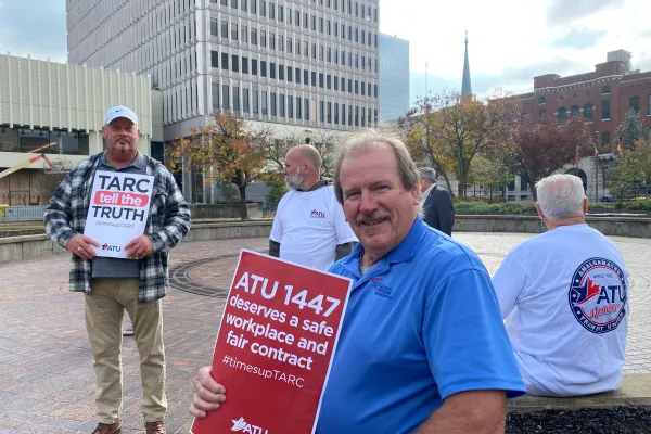Kirk Gillenwaters, holding the red sign, and others at the informational picket.