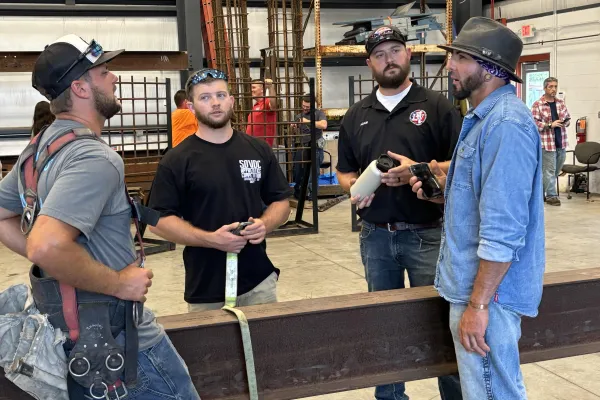 "Monkey" Warden speaks to Local 70 brothers, from left, Brice Sweeney, Logan Kramer and Adam Quinton       Photo by Jerald Adkins
