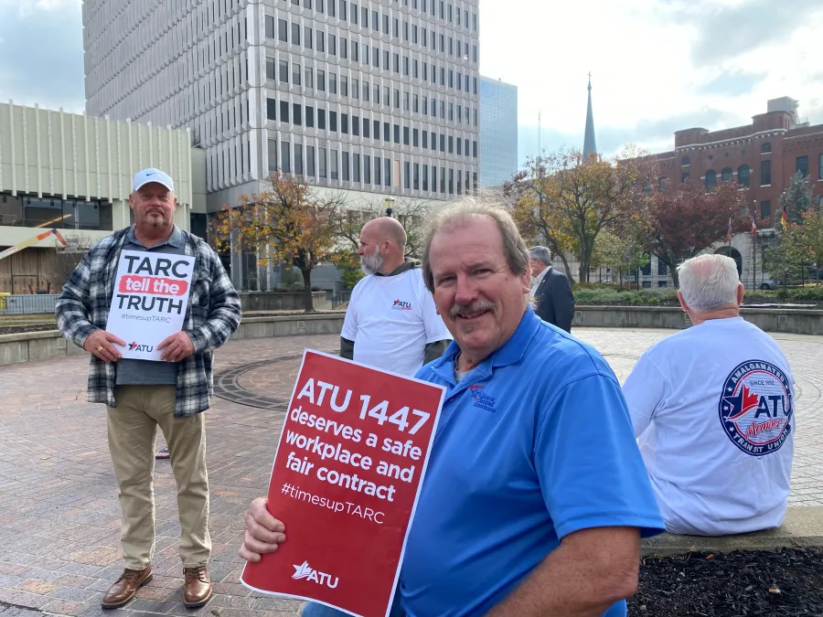Kirk Gillenwaters, holding the red sign, and others at the informational picket.