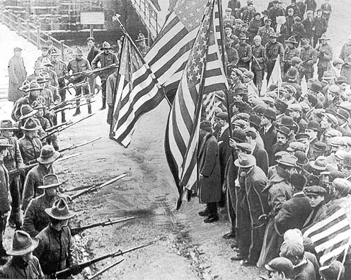 State militia troops challenge peaceful Lawrence, Mass., textile mill strikers led by the Industrial Workers of the World in 1912. Photo from Wikipedia. 